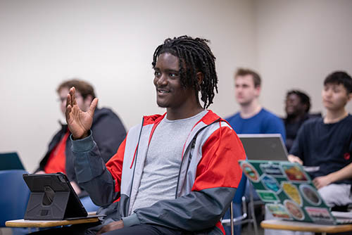 a  Business Administration degree student in missouri at Southeast Missouri State raises his hand to answer a question in class