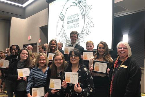 A group of students proudly display their awards.