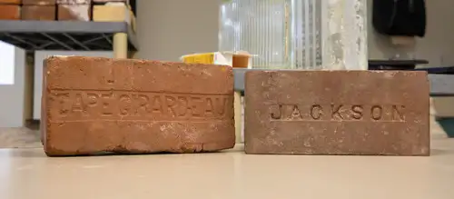 historic preservation degree student's recovery of historic bricks with cape Girardeau and Jackson engraved in them shown on a lab table