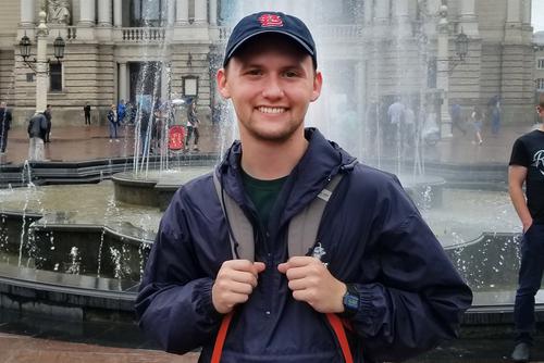 Chase Groshong smiles for a picture in front of a fountain. 