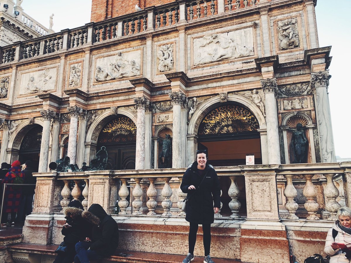 A Southeast student studying abroad poses in front of a historic building.