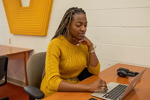 a semo student sits at a table with her laptop