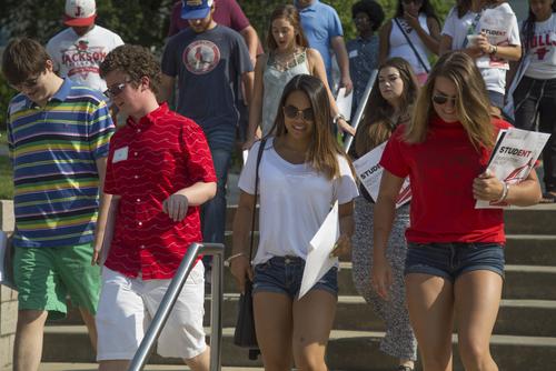 Students carrying orientation packets walk down the steps of Academic Hall during First STEP.