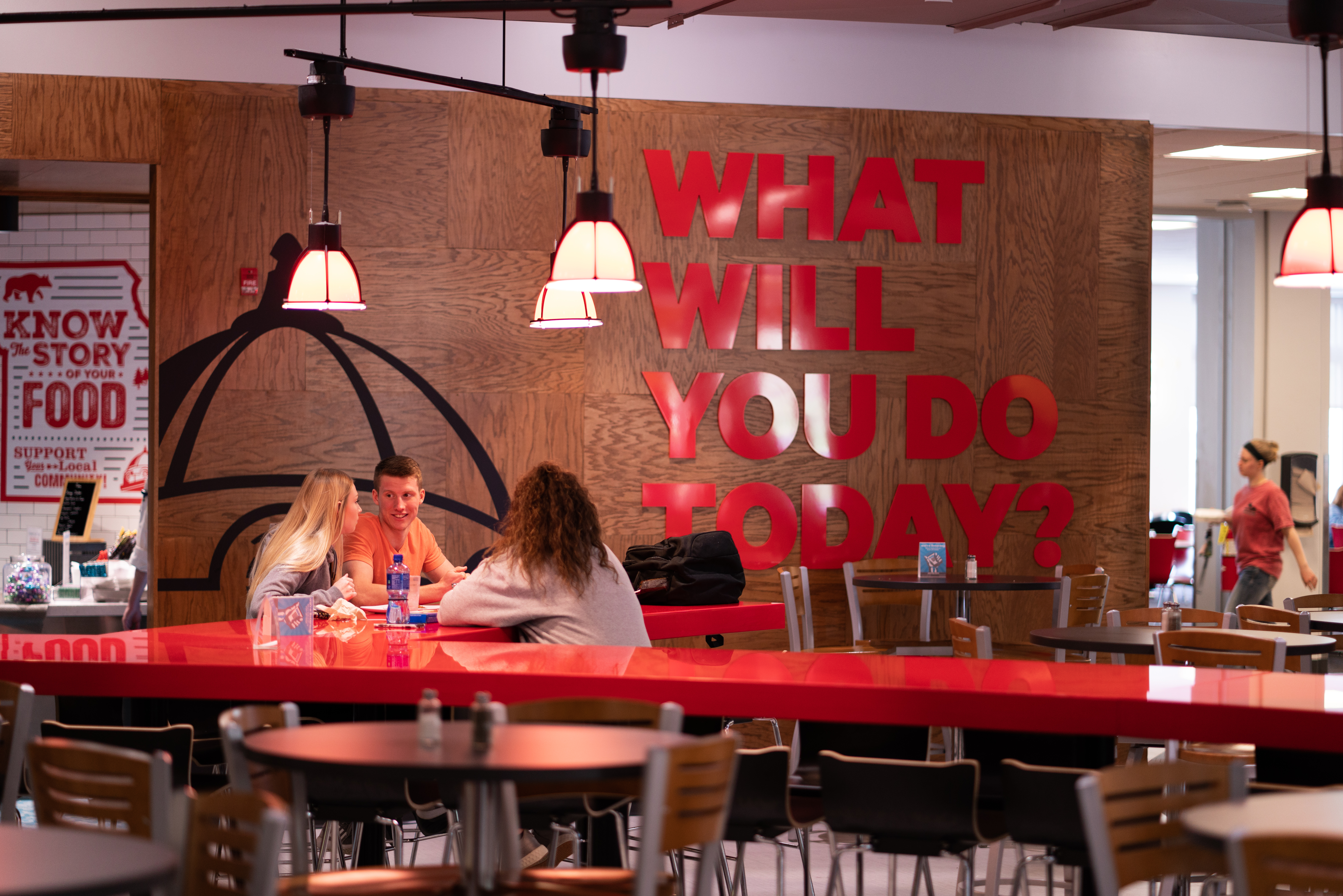Students dine at Towers Café in front of a wall that reads “What will you do today?"