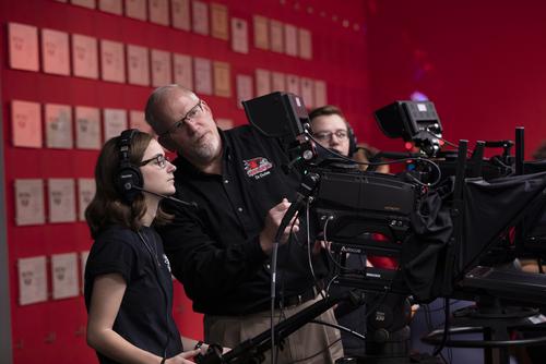 Dr. Dufek shows a student how to use the professional video equipment on set at the Rust Center. 