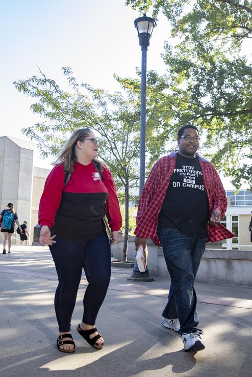 Students pass by the DNA fountain near Rhodes Hall as they walk to class. 
