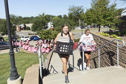 Upperclassmen help freshman carry their things up to their rooms on move-in day.