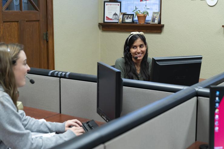 Student workers wearing headsets call alumni on behalf of the University Foundation.