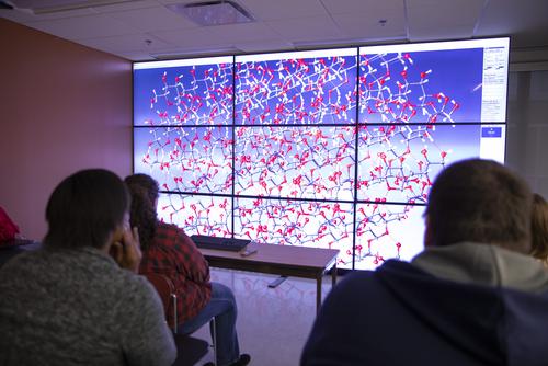 At the Visualization Lab, a grid of large monitors display a computer generated chemical structure. 