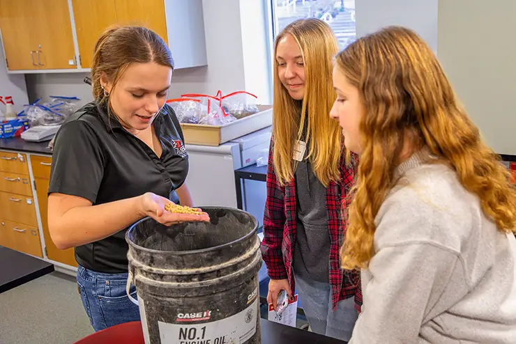 an instructor in agriculture goes through a presentation with visiting high school students