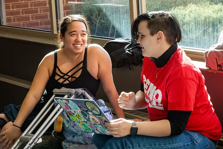 one SEMO student helps another on crutches