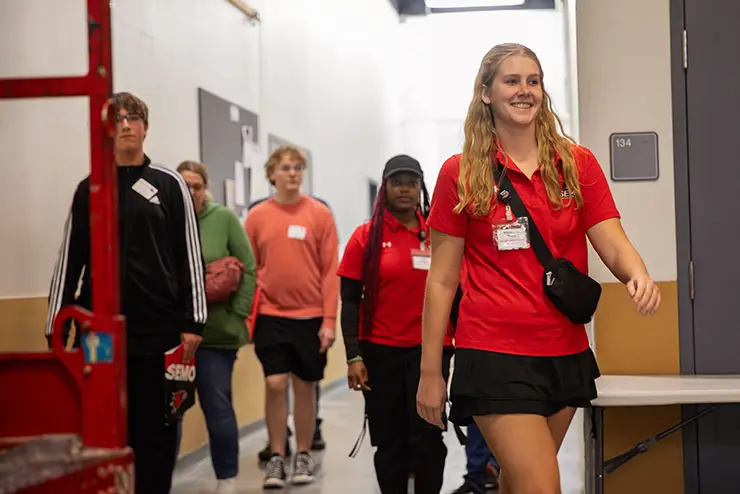 a SEMO tour guide working for admissions leads a group of students through the rec center