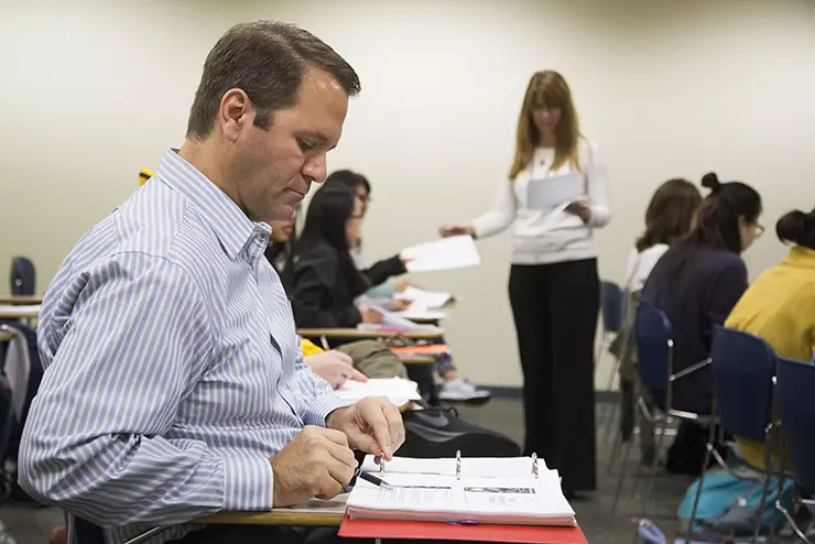 a nontraditional student sits in class at SEMO working in his notebook