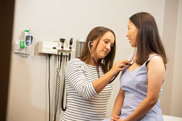 a campus health clinic doctor examines a patient