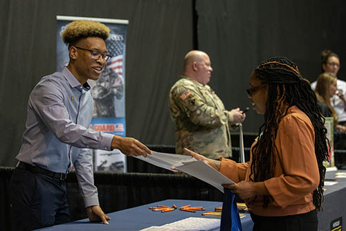 Professionally dressed students practice networking at the Career Services Etiquette Dinner.