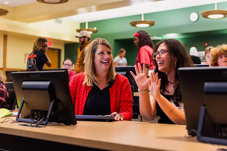 an advisor and a nontraditional adult student work together during orientation to make a schedule