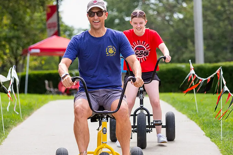 a SEMO dad races his student on bigwheel bikes during family weekend
