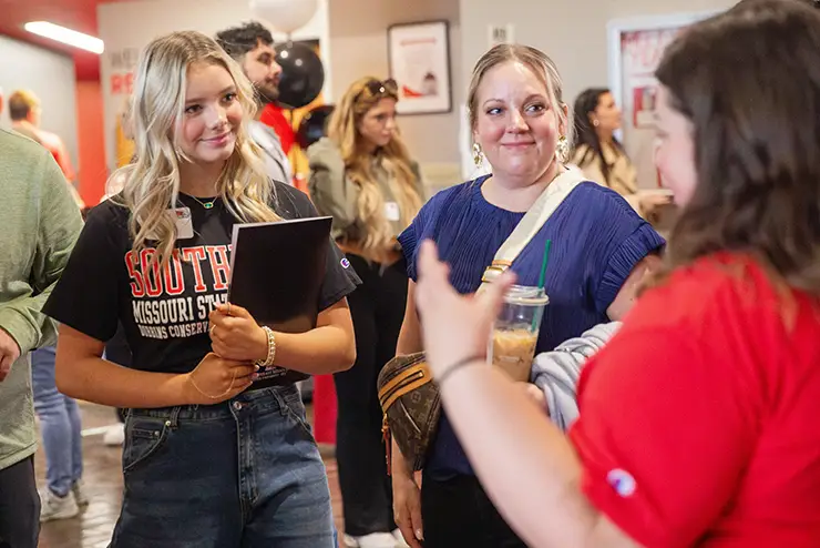 a SEMO student and her parent walk to a SEMO employee about scholarships