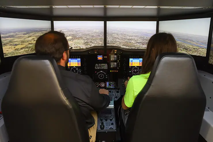 a regional high school student sits with a SEMO instructor in the flight simulator