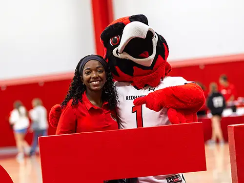 a prospective semo student at show me day posts for a photo with Rowdy the Redhawk