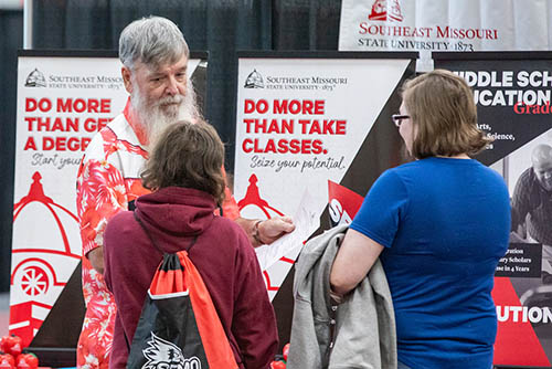 high school students participating in Show Me College Visit Day stop to talk to a university professor about classes and degrees
