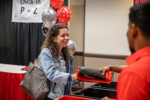 Show Me Day attendees pick up event merch, including a free Redhawk t-shirt during the best day to visit colleges