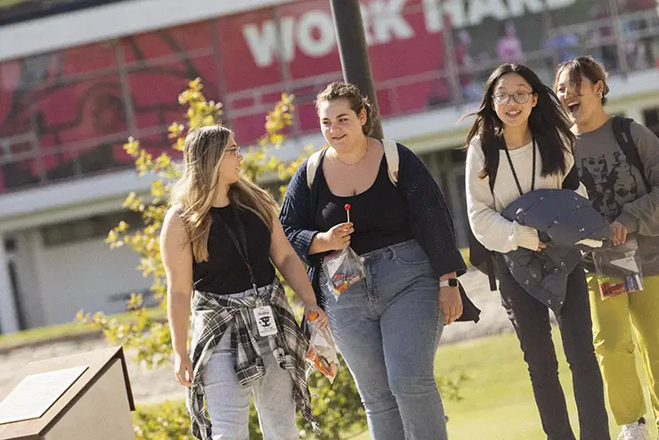 a group of SEMO students crosses camps, talking and laughing