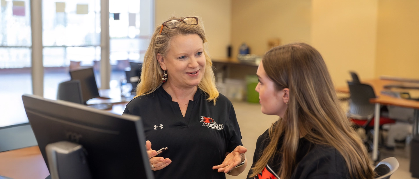an instructor helps a group of students with their coursework