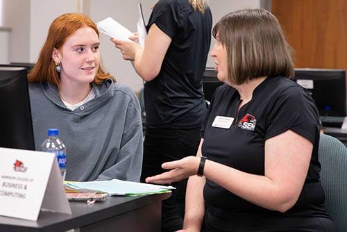 a Southeast advisor sits with a student at a computer and walks them through enrolling in classes