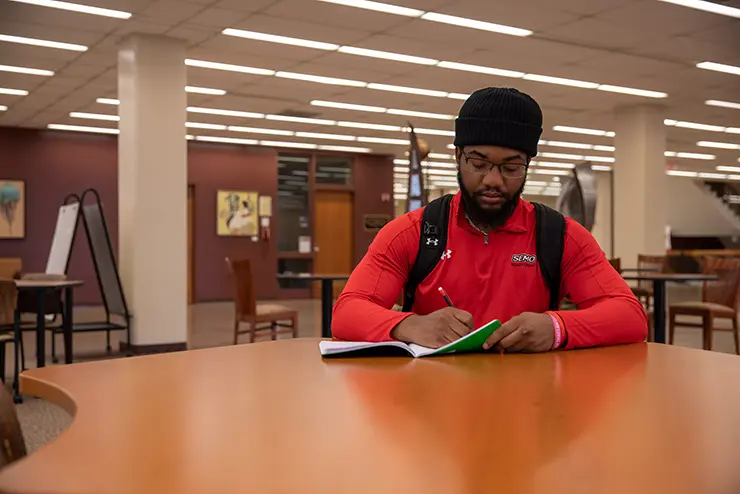 a SEMO student in the library reads a magazine