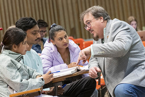an instructor helps a group of students with their coursework