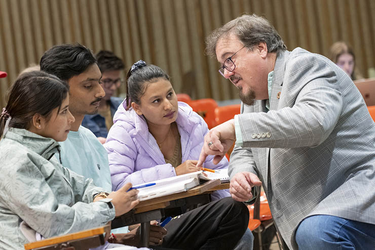 an instructor helps a group of students with their coursework