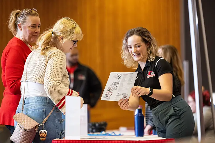 an admissions employee goes over a campus map with visiting high school students