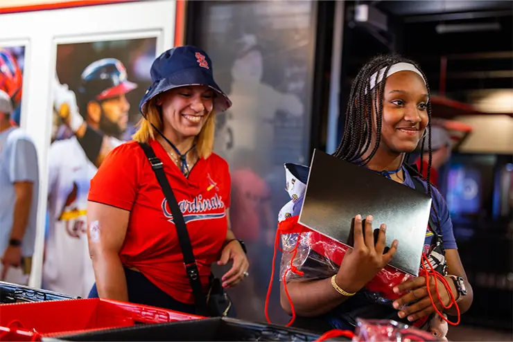 Two alumni happily entering Busch Stadium