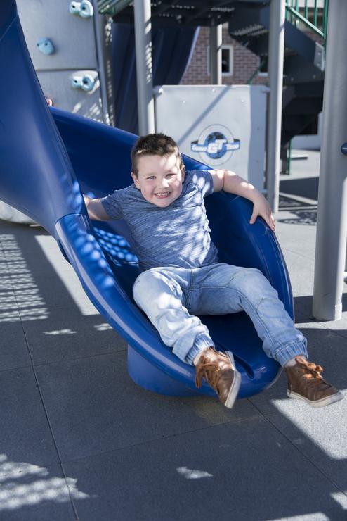 a student of the autism center plays on a slide