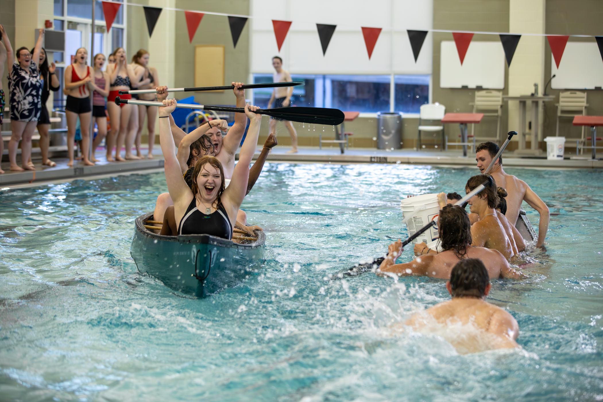 Students engaging in a match of kayak battle ship in the Aquatic Center pool.