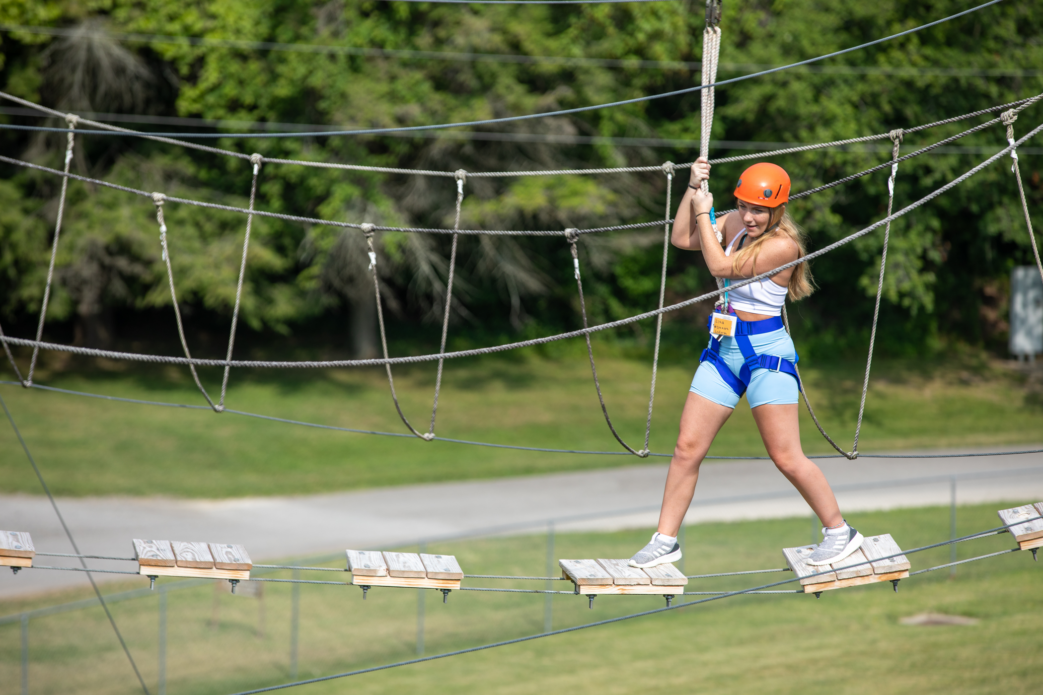 Student weaving her way through the ropes course at Camp Redhawk. 