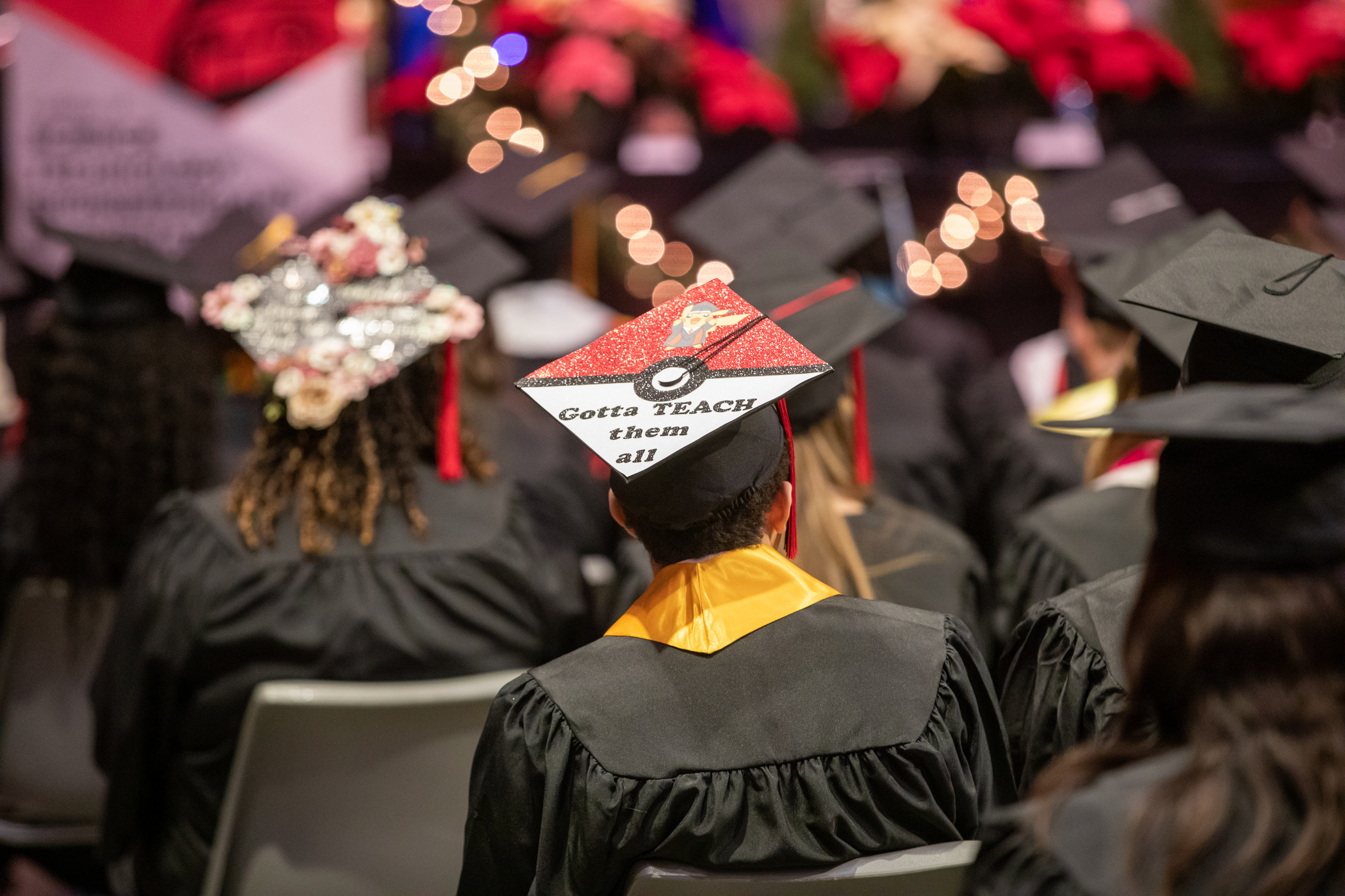 Pokemon themed cap that is decorated like a Poke ball. It reads, "Gotta teach them all."