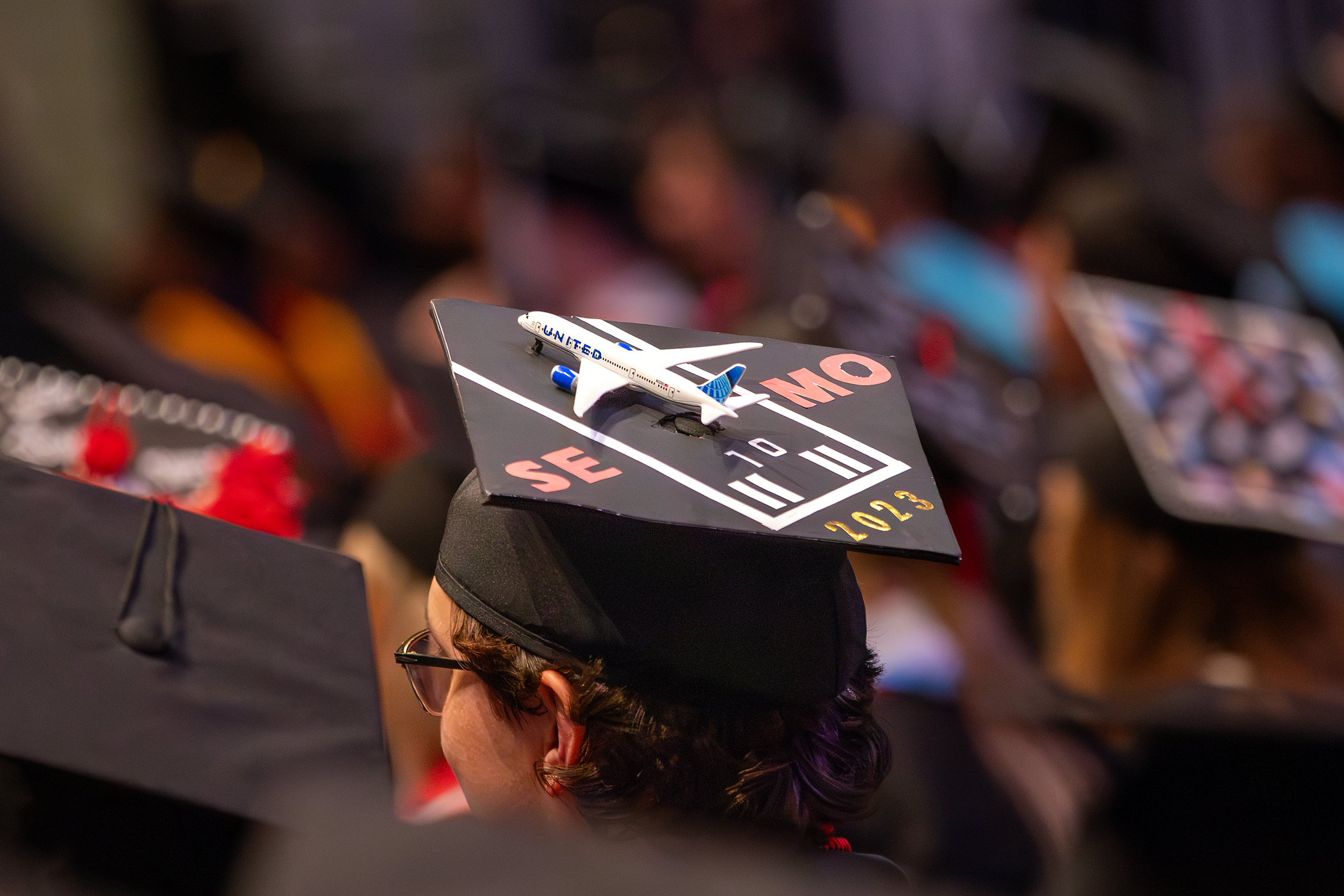 Graduation decorated with a toy plane. It looks as if it is about to take flight off of the cap.