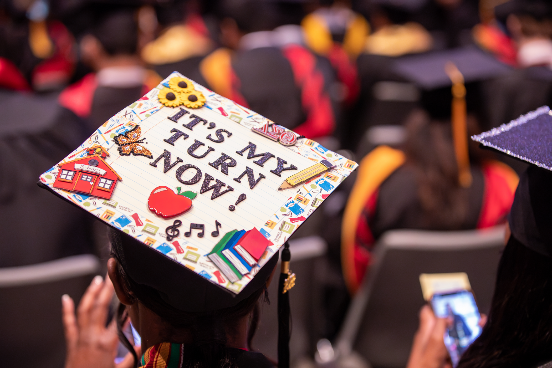 A SEMO graduate wearing their graduation cap that reads, "It's my turn now!"