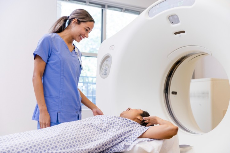 A technician prepares a patient for a CT scan.