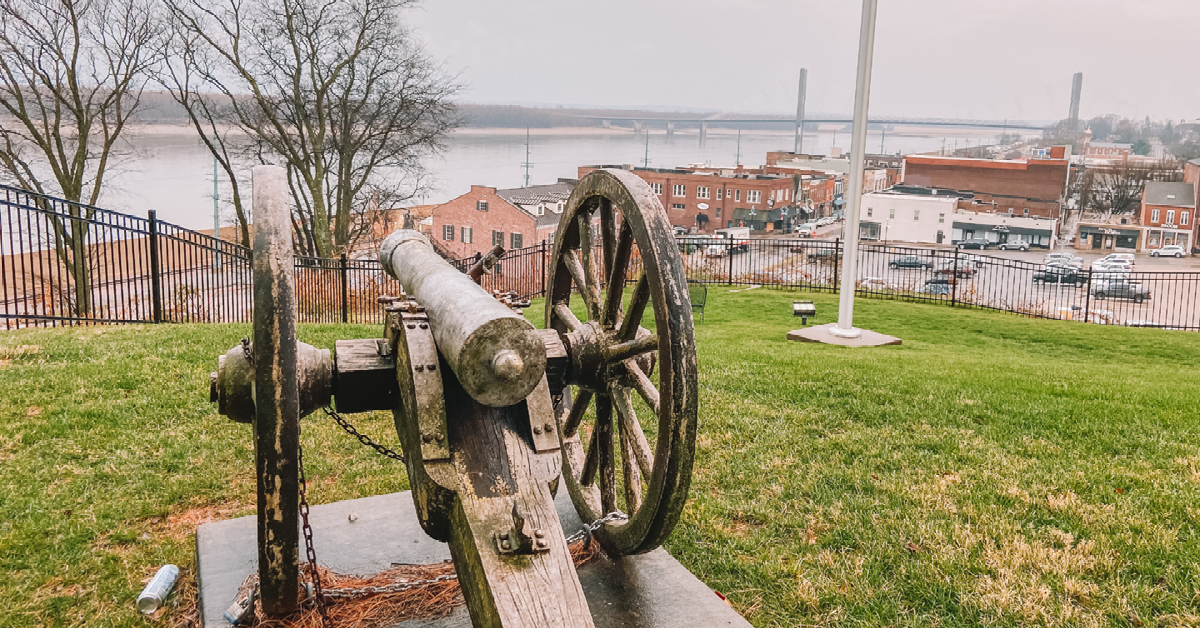 An old canon sitting on top of a hill overlooking the Mississippi River