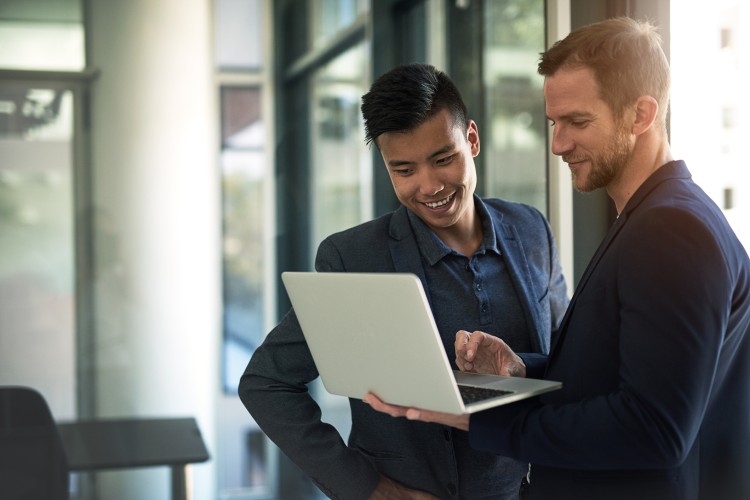 A technical project manager talks with a project team member.