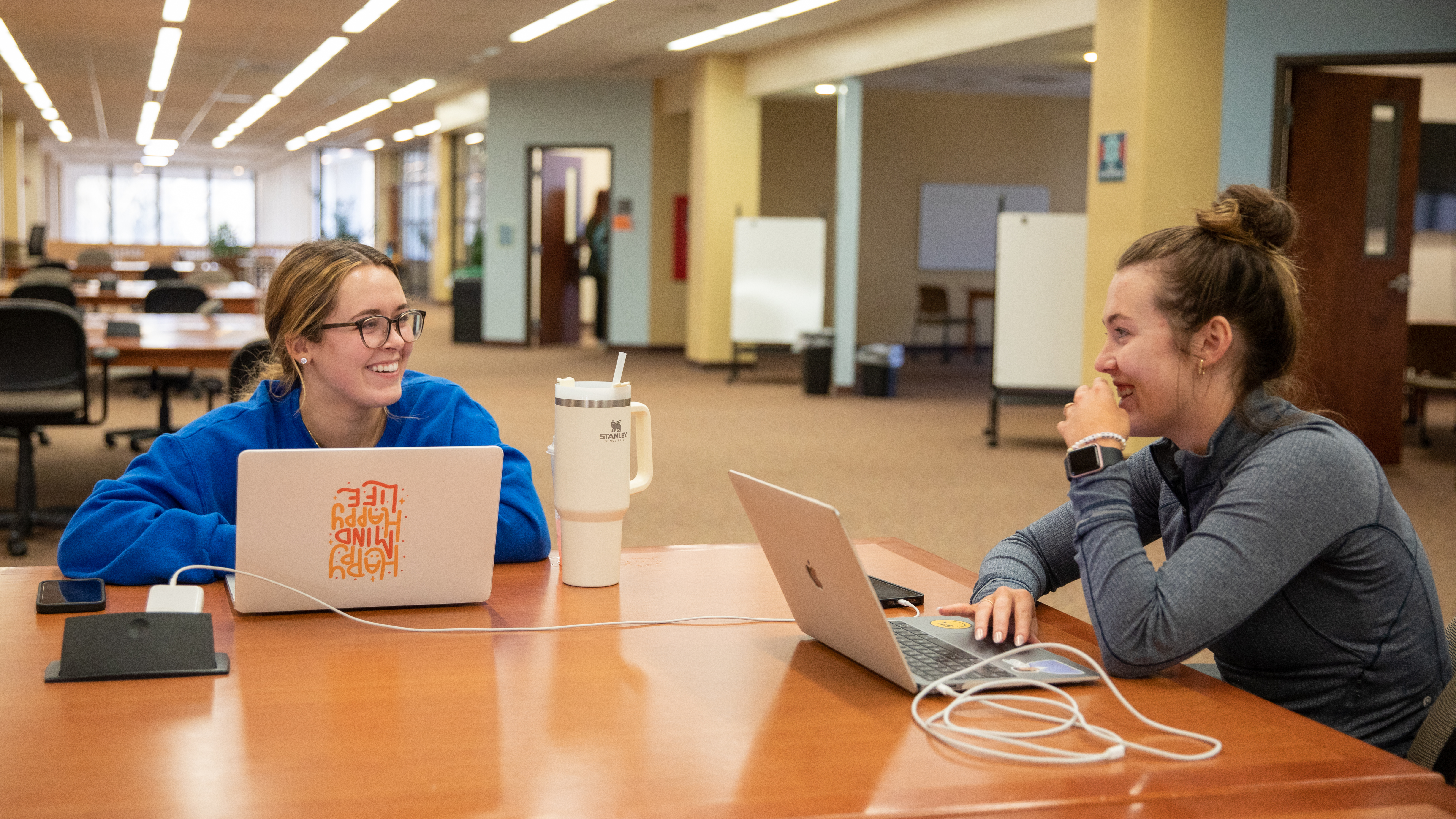 Two students sitting around a table studying in Kent Library.