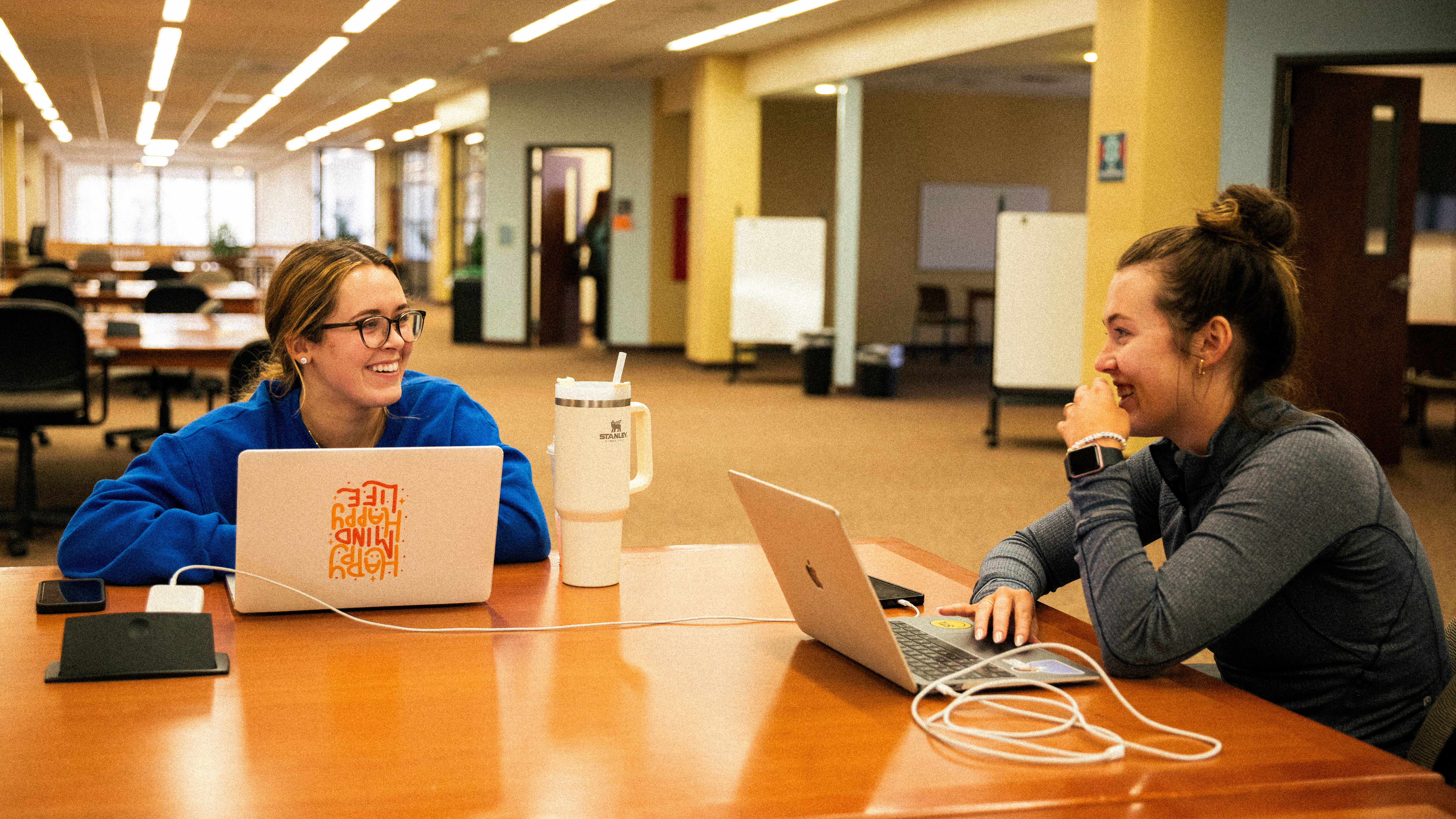 two college students sitting in Kent Library studying on laptops at Southeast Missouri State University.
