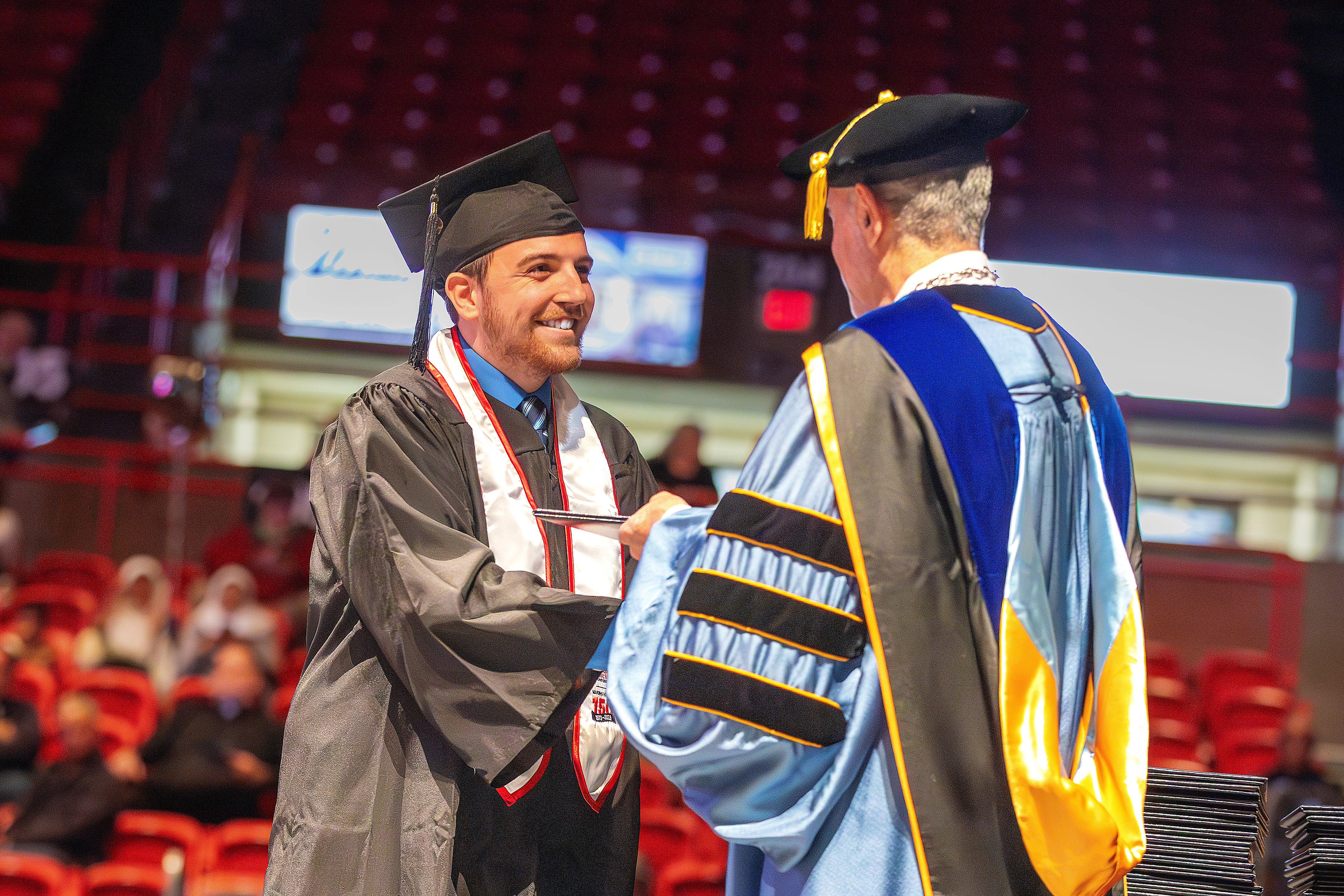 Student walking across the stage at graduation.