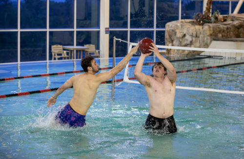 Two students playing basketball in the pool at the student aquatic center,