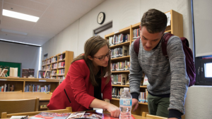 An staff member helps a student understand the cost of college.