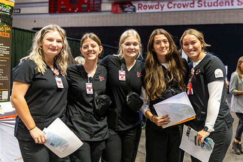 A group of students smile at the Career Fair