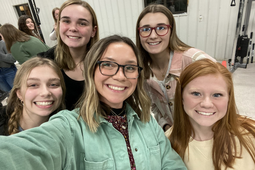 Erica and friends smile for a photo at an organization event.